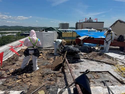 The crewmen is properly protected from potential ACM and is harnessed in dangerous areas. 