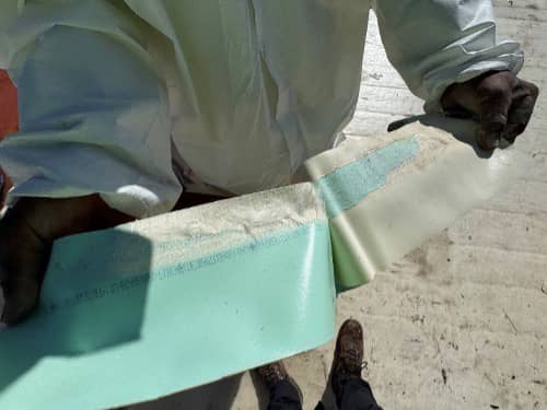 After heat welding seams of roof membrane, checking quality the seam by pulling. 