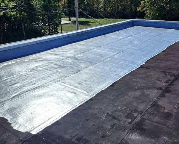 Initial application of pourable membrane over bituminous surface 
